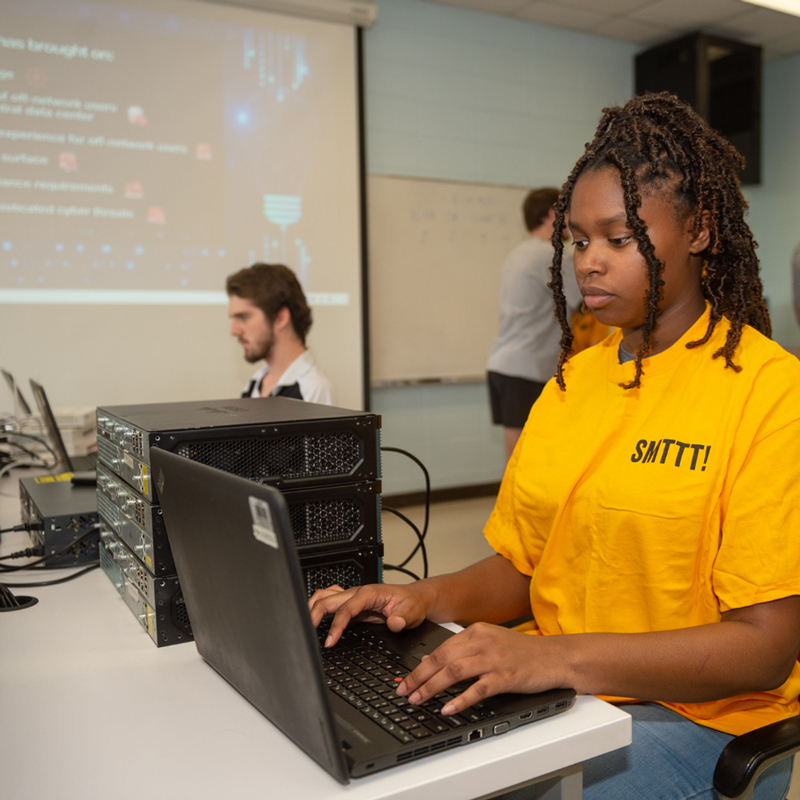 Two Computing Students typing