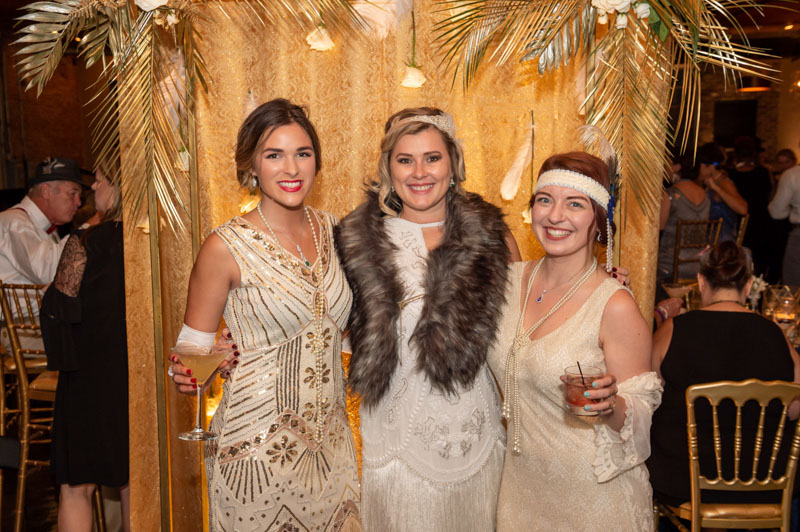 Three attendees pose for a photo at the event