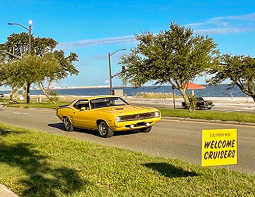 gold sporty classic car cruising the highway on the beach