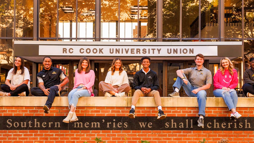 students sitting on wall