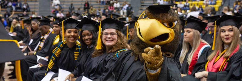 Seymour sitting with seated graduates